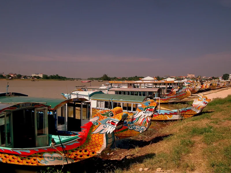 Colorful dragon-headed boats moored along the bank of the Perfume River in Hue.